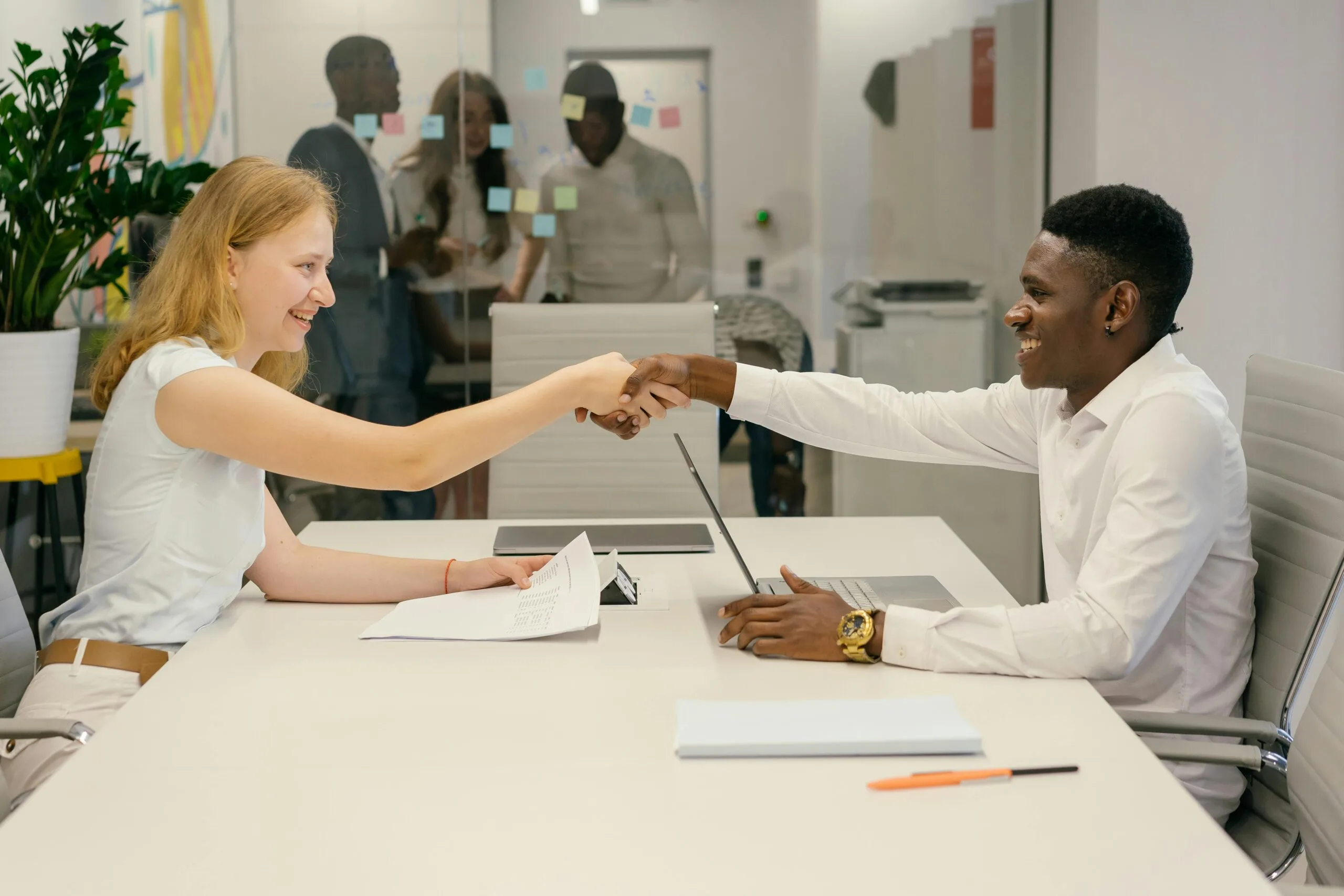 Free Business professionals completing a successful deal with a handshake in a modern office setting. Stock Photo